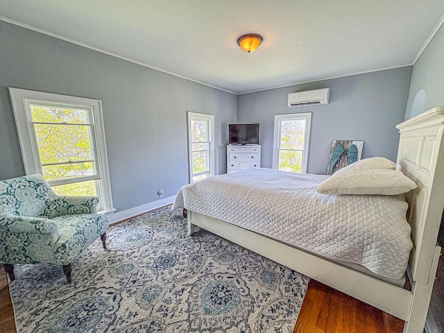 bedroom featuring an AC wall unit, wood finished floors, crown molding, and baseboards