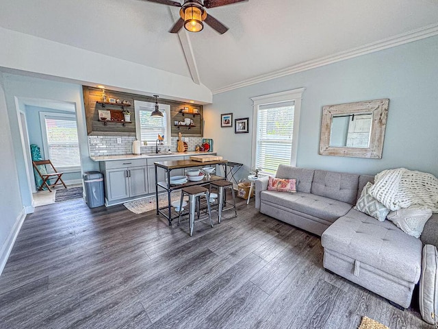 living room with dark wood-type flooring, a ceiling fan, ornamental molding, and baseboards