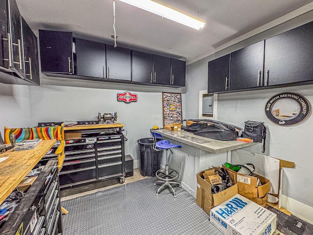 kitchen featuring dark cabinets, light countertops, and baseboards