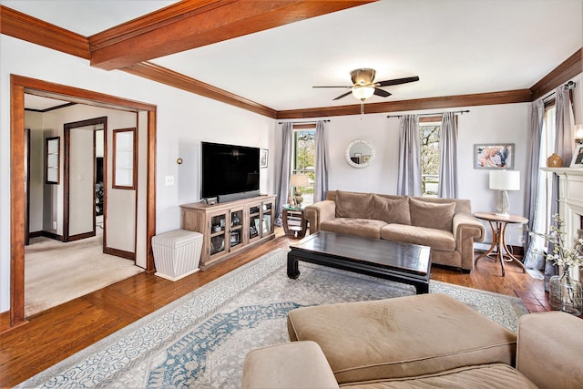 living room featuring ornamental molding, a ceiling fan, hardwood / wood-style flooring, and baseboards