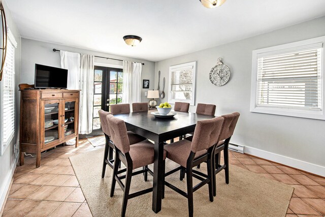 dining space with plenty of natural light, light tile patterned floors, french doors, and baseboards