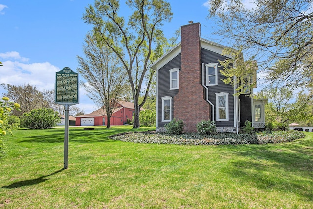 rear view of property with a chimney and a lawn