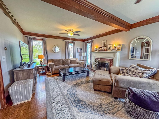 living room with crown molding, wood-type flooring, a fireplace, ceiling fan, and a textured ceiling
