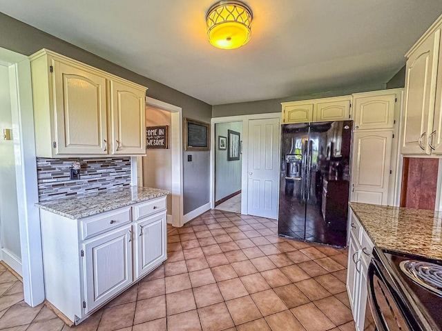 kitchen featuring black appliances, decorative backsplash, light tile patterned flooring, baseboards, and light stone countertops