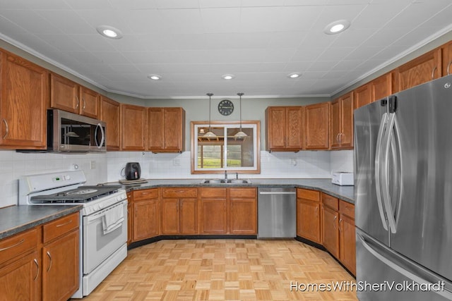 kitchen with appliances with stainless steel finishes, brown cabinetry, dark countertops, and recessed lighting