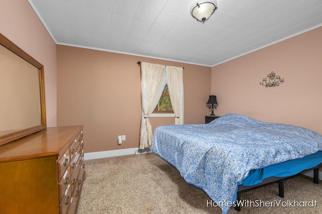 carpeted bedroom with ornamental molding and baseboards