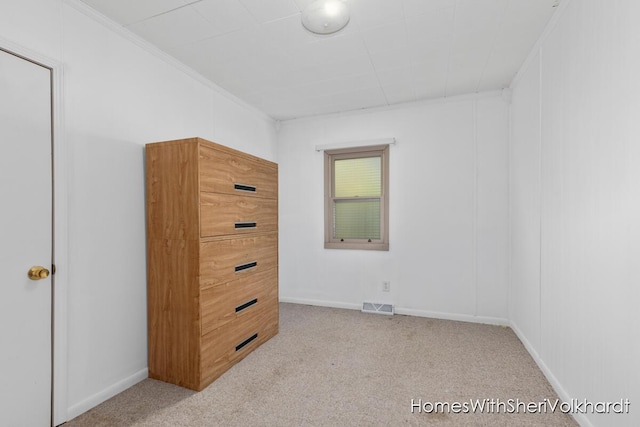 unfurnished bedroom featuring carpet floors, crown molding, and baseboards