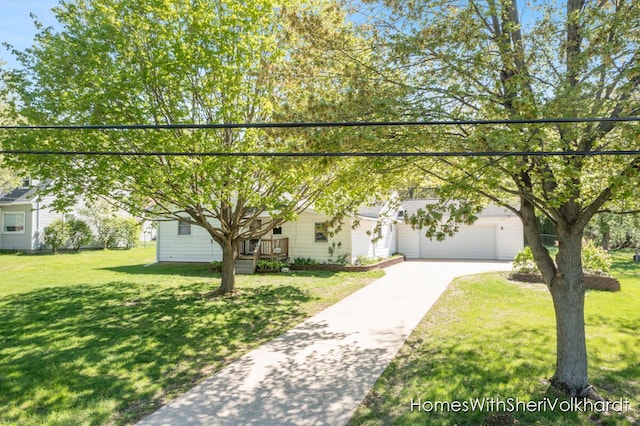 view of property hidden behind natural elements with concrete driveway, a front lawn, and a garage