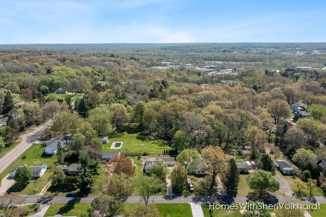 aerial view of property and surrounding area with a heavily wooded area