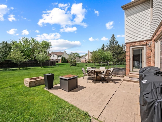 view of patio featuring an outdoor fire pit, outdoor dining area, and grilling area
