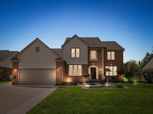traditional-style house featuring driveway, an attached garage, a front yard, and brick siding