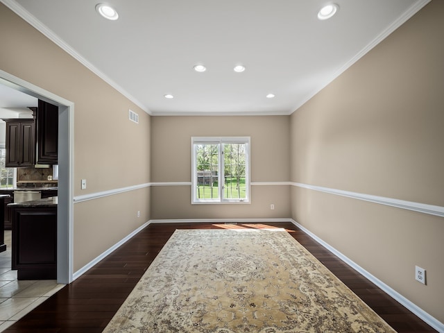 empty room featuring dark wood-style floors, recessed lighting, baseboards, and ornamental molding