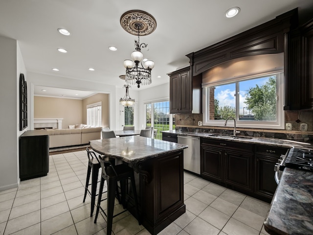 kitchen with stainless steel dishwasher, a sink, decorative backsplash, a center island, and recessed lighting