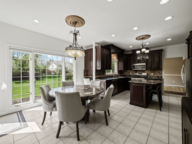 dining area with a chandelier, recessed lighting, and light tile patterned floors