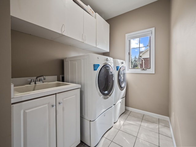 washroom featuring cabinet space, washer and clothes dryer, baseboards, and light tile patterned floors