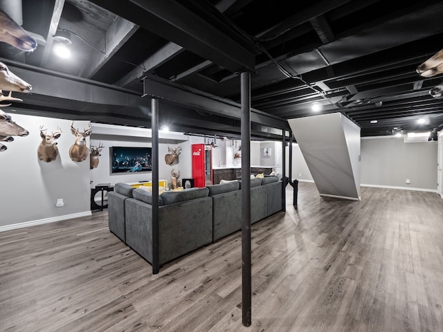 finished basement featuring wood finished floors and baseboards