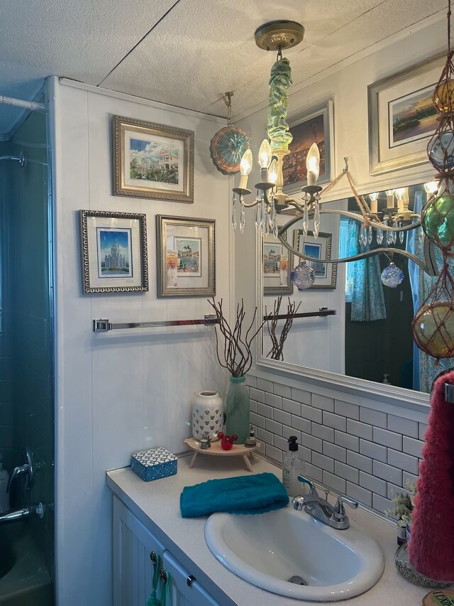 bathroom with backsplash, vanity, and a textured ceiling