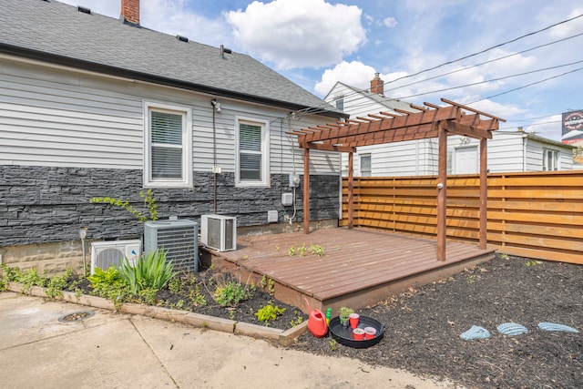 wooden deck with a fenced backyard, a pergola, and cooling unit