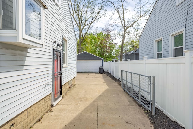 view of property exterior with fence, a garage, and an outdoor structure