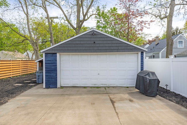detached garage featuring fence