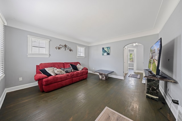 living room featuring arched walkways, wood-type flooring, and baseboards