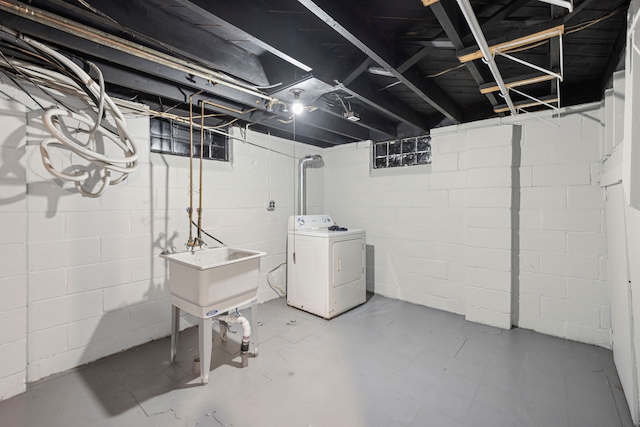 unfinished below grade area featuring washer / clothes dryer and a sink