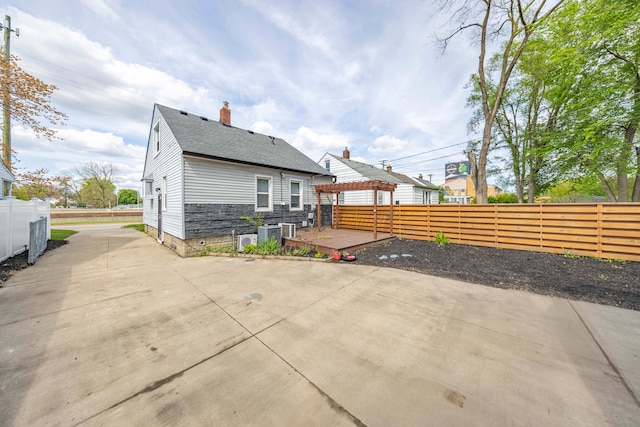 back of house with a deck, a fenced backyard, and a patio area