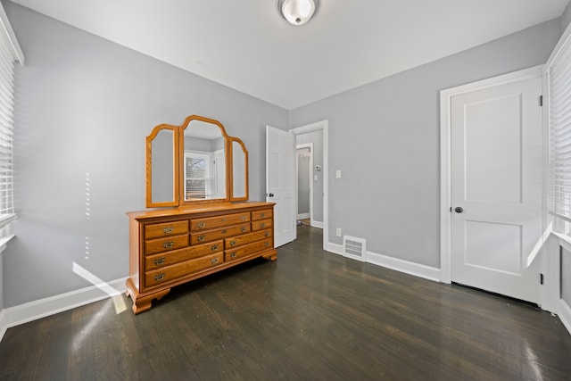 bedroom with dark wood finished floors and baseboards