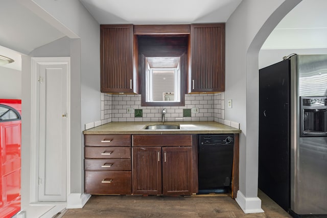 kitchen featuring stainless steel refrigerator with ice dispenser, a sink, dark wood finished floors, light countertops, and decorative backsplash