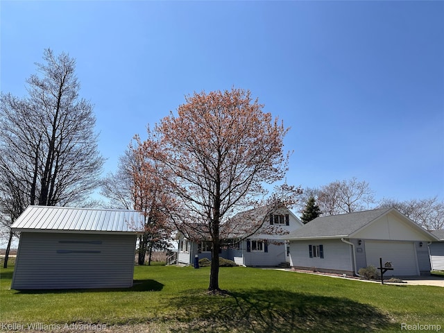 2800 E Booth Rd, Au Gres, MI 48703 - view of grassy yard with a garage, concrete driveway, and an outbuilding