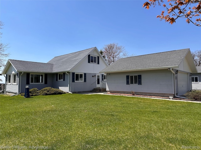 2800 E Booth Rd, Au Gres, MI 48703 - rear view of house featuring entry steps, a garage, a yard, and a shingled roof