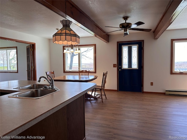 2800 E Booth Rd, Au Gres, MI 48703 - kitchen with a sink, dark wood-type flooring, a baseboard heating unit, beam ceiling, and a textured ceiling
