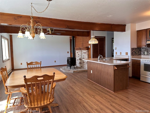 2800 E Booth Rd, Au Gres, MI 48703 - dining room with a wood stove, dark wood-style floors, beamed ceiling, a chandelier, and ceiling fan