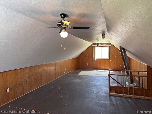 2800 E Booth Rd, Au Gres, MI 48703 - bonus room featuring wooden walls, a ceiling fan, a textured ceiling, and lofted ceiling