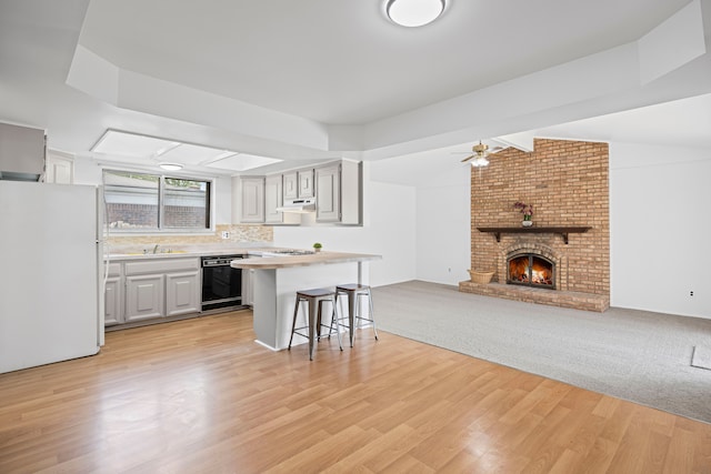 13488 Kingsville Dr, Sterling Heights, MI 48312 - kitchen with freestanding refrigerator, dishwasher, a kitchen bar, open floor plan, and extractor fan