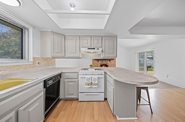 13488 Kingsville Dr, Sterling Heights, MI 48312 - kitchen with gas range gas stove, black dishwasher, a raised ceiling, under cabinet range hood, and a peninsula