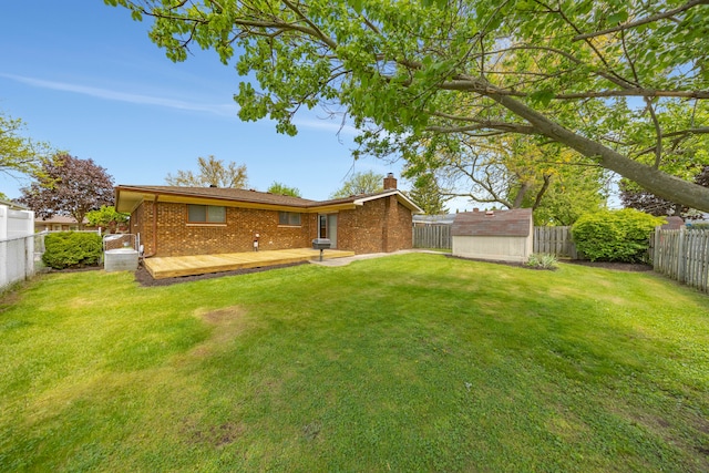 13488 Kingsville Dr, Sterling Heights, MI 48312 - rear view of house with a chimney, a shed, a wooden deck, an outdoor structure, and brick siding