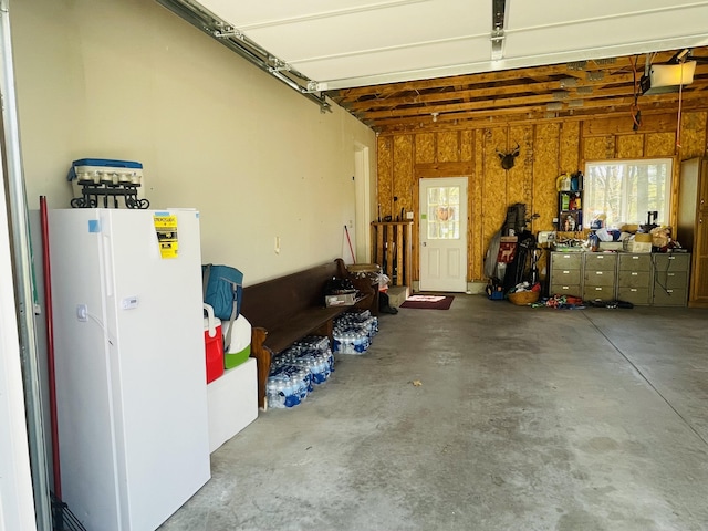 9612 Clubhouse Dr W, Canadian Lakes, MI 49346 - garage featuring freestanding refrigerator and a garage door opener