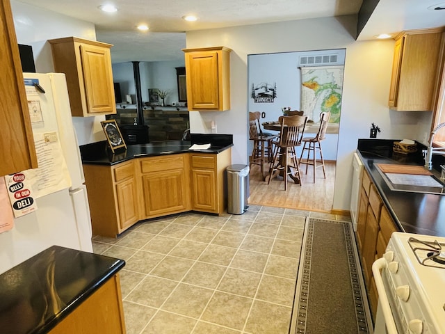 9612 Clubhouse Dr W, Canadian Lakes, MI 49346 - kitchen with white appliances, recessed lighting, dark countertops, light tile patterned flooring, and a sink