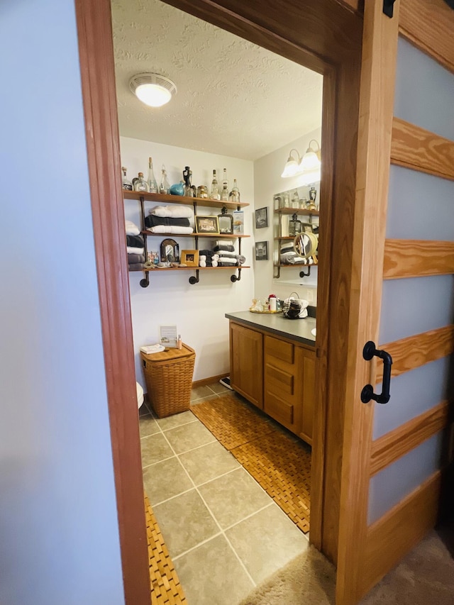 9612 Clubhouse Dr W, Canadian Lakes, MI 49346 - bathroom featuring tile patterned floors, vanity, and a textured ceiling