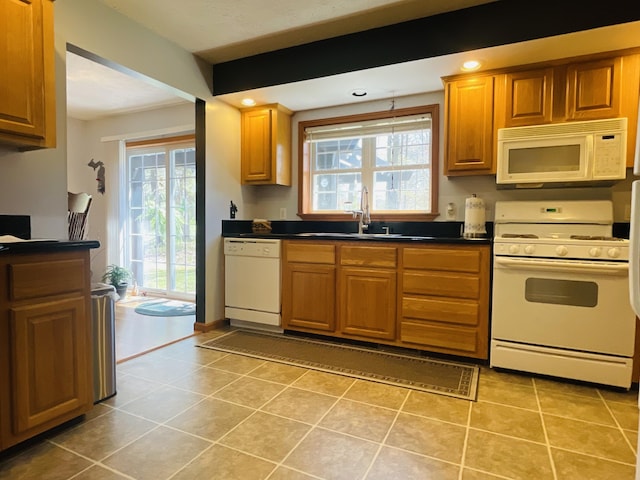9612 Clubhouse Dr W, Canadian Lakes, MI 49346 - kitchen with white appliances, a sink, dark countertops, light tile patterned floors, and brown cabinetry