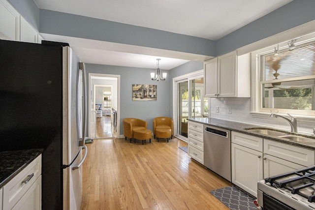 2021 Skyler Dr, Kalamazoo, MI 49008 - kitchen with appliances with stainless steel finishes, a sink, a chandelier, and light wood finished floors