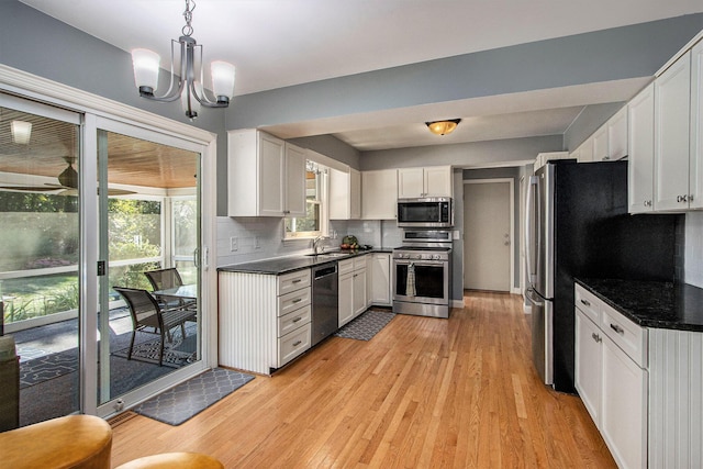 2021 Skyler Dr, Kalamazoo, MI 49008 - kitchen with stainless steel appliances, dark countertops, and light wood-type flooring