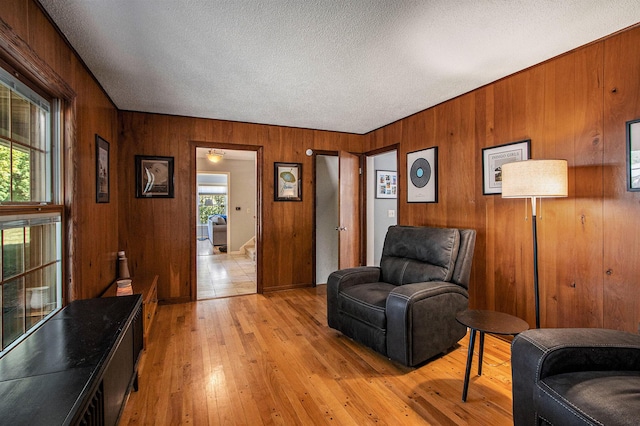 2021 Skyler Dr, Kalamazoo, MI 49008 - sitting room featuring wood walls, a textured ceiling, and light wood-style flooring