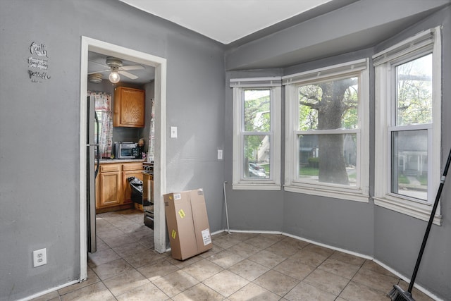 dining space featuring light tile patterned flooring, ceiling fan, and baseboards