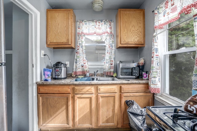 kitchen featuring healthy amount of natural light, a sink, range with electric cooktop, and light countertops