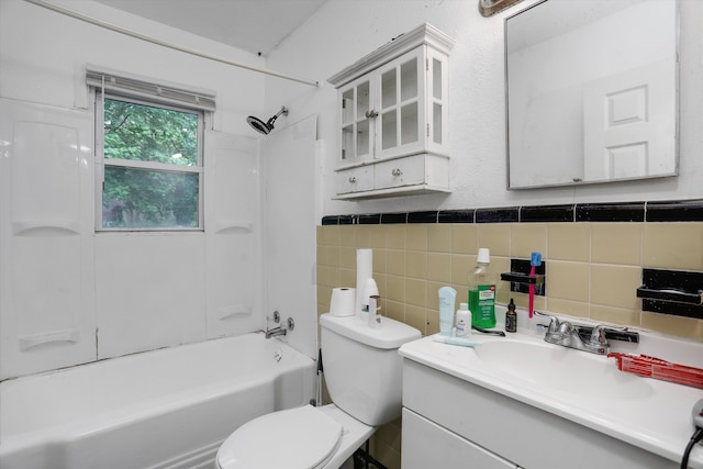 bathroom featuring toilet, tile walls, washtub / shower combination, vanity, and a wainscoted wall