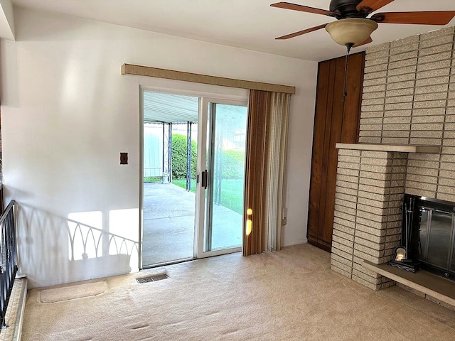 unfurnished living room with carpet flooring, a ceiling fan, and a fireplace