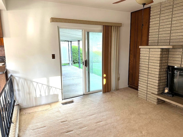 unfurnished living room with carpet, a fireplace, and a ceiling fan