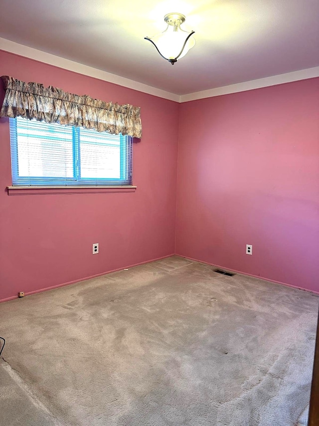 spare room featuring plenty of natural light, carpet flooring, and baseboards
